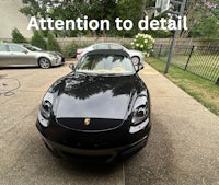 a black porsche boxster parked in front of a house